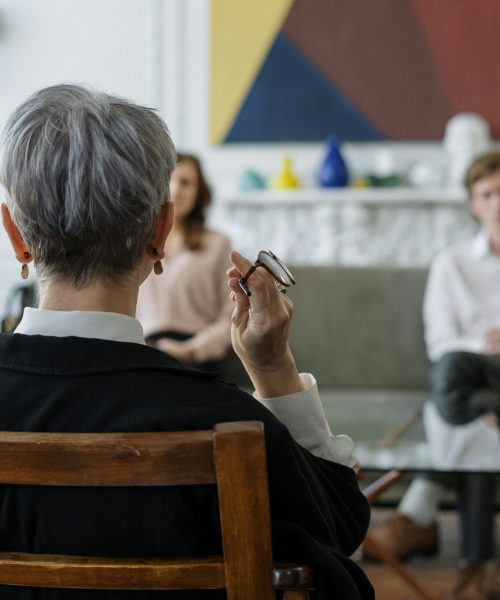 A therapist leads a couple's therapy session in a modern office setting.